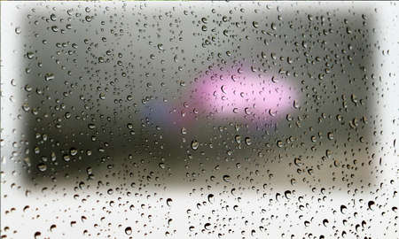 Background with rain drops close up. Rain drops on outdoor window, Closeup view transparent water drops on glass surface, humid water backdrop, blurred background with copy space for your textの写真素材