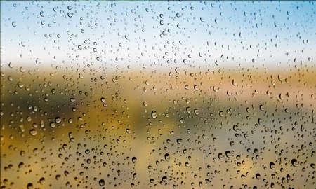 Background with rain drops close up. Rain drops on outdoor window, Closeup view transparent water drops on glass surface, humid water backdrop, blurred background with copy space for your textの写真素材
