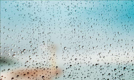 Background with rain drops close up. Rain drops on outdoor window, Closeup view transparent water drops on glass surface, humid water backdrop, blurred background with copy space for your textの写真素材