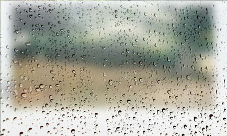 Background with rain drops close up. Rain drops on outdoor window, Closeup view transparent water drops on glass surface, humid water backdrop, blurred background with copy space for your textの写真素材