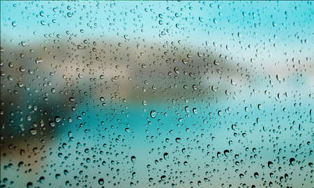 Background with rain drops close up. Rain drops on outdoor window, Closeup view transparent water drops on glass surface, humid water backdrop, blurred background with copy space for your textの写真素材