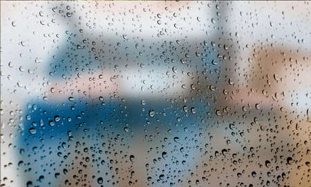 Background with rain drops close up. Rain drops on outdoor window, Closeup view transparent water drops on glass surface, humid water backdrop, blurred background with copy space for your textの写真素材
