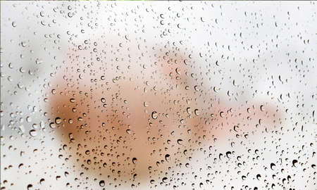 Background with rain drops close up. Rain drops on outdoor window, Closeup view transparent water drops on glass surface, humid water backdrop, blurred background with copy space for your textの写真素材