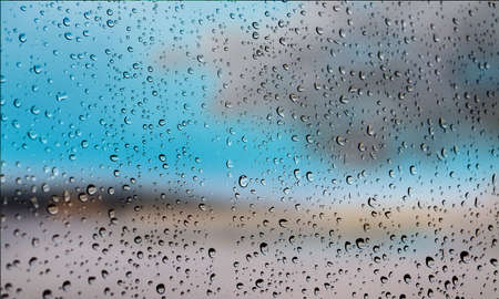 Background with rain drops close up. Rain drops on outdoor window, Closeup view transparent water drops on glass surface, humid water backdrop, blurred background with copy space for your textの写真素材