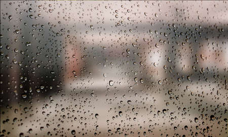 Background with rain drops close up. Rain drops on outdoor window, Closeup view transparent water drops on glass surface, humid water backdrop, blurred background with copy space for your textの写真素材