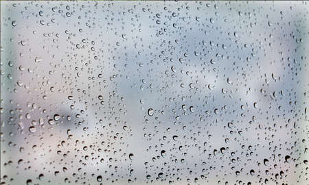 Background with rain drops close up. Rain drops on outdoor window, Closeup view transparent water drops on glass surface, humid water backdrop, blurred background with copy space for your textの写真素材