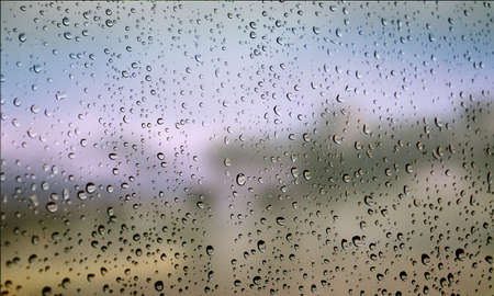 Background with rain drops close up. Rain drops on outdoor window, Closeup view transparent water drops on glass surface, humid water backdrop, blurred background with copy space for your textの写真素材