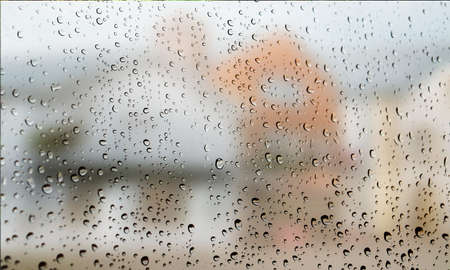 Background with rain drops close up. Rain drops on outdoor window, Closeup view transparent water drops on glass surface, humid water backdrop, blurred background with copy space for your textの写真素材