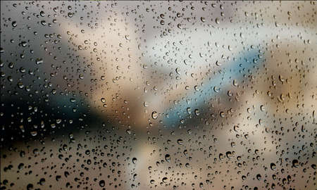 Background with rain drops close up. Rain drops on outdoor window, Closeup view transparent water drops on glass surface, humid water backdrop, blurred background with copy space for your textの写真素材