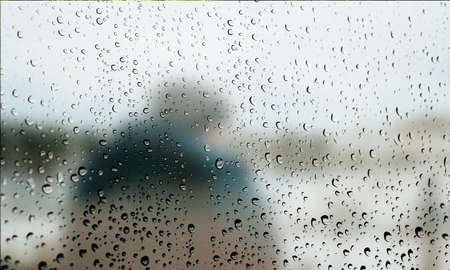 Background with rain drops close up. Rain drops on outdoor window, Closeup view transparent water drops on glass surface, humid water backdrop, blurred background with copy space for your textの写真素材