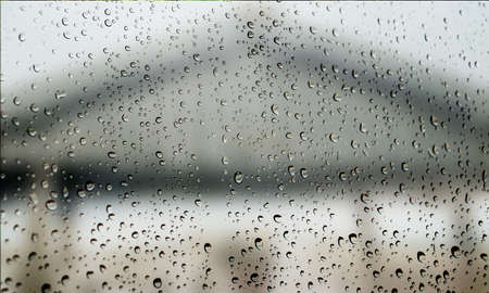 Background with rain drops close up. Rain drops on outdoor window, Closeup view transparent water drops on glass surface, humid water backdrop, blurred background with copy space for your textの写真素材