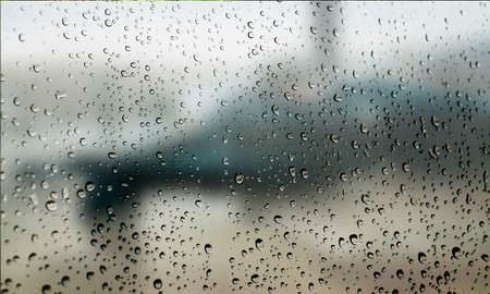 Background with rain drops close up. Rain drops on outdoor window, Closeup view transparent water drops on glass surface, humid water backdrop, blurred background with copy space for your textの写真素材