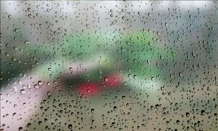 Background with rain drops close up. Rain drops on outdoor window, Closeup view transparent water drops on glass surface, humid water backdrop, blurred background with copy space for your textの写真素材
