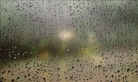 Background with rain drops close up. Rain drops on outdoor window, Closeup view transparent water drops on glass surface, humid water backdrop, blurred background with copy space for your textの写真素材