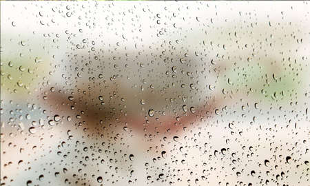 Background with rain drops close up. Rain drops on outdoor window, Closeup view transparent water drops on glass surface, humid water backdrop, blurred background with copy space for your textの写真素材