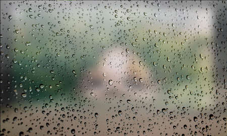 Background with rain drops close up. Rain drops on outdoor window, Closeup view transparent water drops on glass surface, humid water backdrop, blurred background with copy space for your textの写真素材