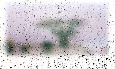 Background with rain drops close up. Rain drops on outdoor window, Closeup view transparent water drops on glass surface, humid water backdrop, blurred background with copy space for your textの写真素材