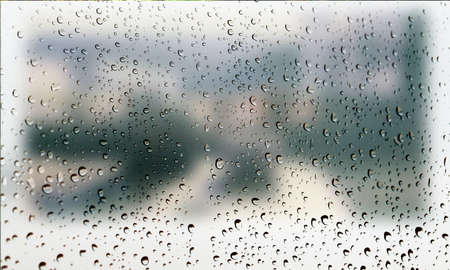 Background with rain drops close up. Rain drops on outdoor window, Closeup view transparent water drops on glass surface, humid water backdrop, blurred background with copy space for your textの写真素材