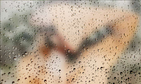 Background with rain drops close up. Rain drops on outdoor window, Closeup view transparent water drops on glass surface, humid water backdrop, blurred background with copy space for your textの写真素材
