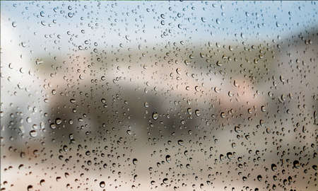 Background with rain drops close up. Rain drops on outdoor window, Closeup view transparent water drops on glass surface, humid water backdrop, blurred background with copy space for your textの写真素材