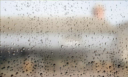 Background with rain drops close up. Rain drops on outdoor window, Closeup view transparent water drops on glass surface, humid water backdrop, blurred background with copy space for your textの写真素材