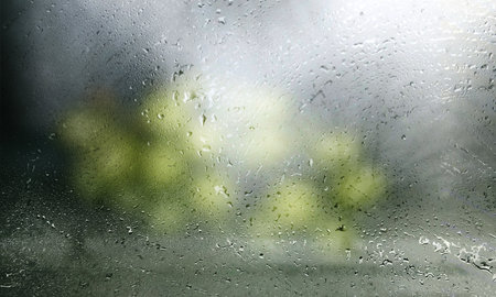 Background with rain drops close up. Rain drops on outdoor window, Closeup view transparent water drops on glass surface, humid water backdrop, blurred background with copy space for your textの写真素材