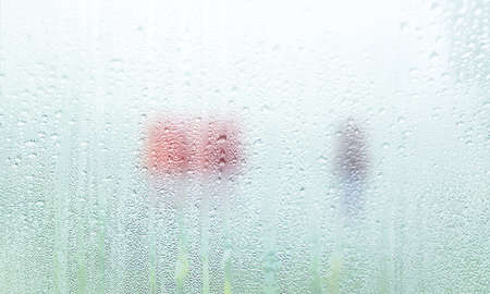 Background with rain drops close up. Rain drops on outdoor window, Closeup view transparent water drops on glass surface, humid water backdrop, blurred background with copy space for your textの写真素材