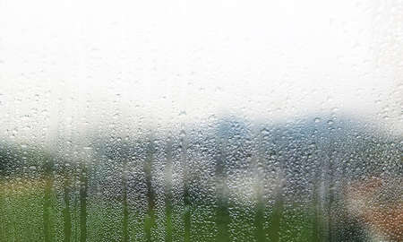 Background with rain drops close up. Rain drops on outdoor window, Closeup view transparent water drops on glass surface, humid water backdrop, blurred background with copy space for your textの写真素材