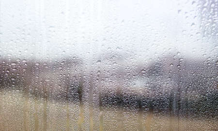 Background with rain drops close up. Rain drops on outdoor window, Closeup view transparent water drops on glass surface, humid water backdrop, blurred background with copy space for your textの写真素材