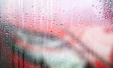 Background with rain drops close up. Rain drops on outdoor window, Closeup view transparent water drops on glass surface, humid water backdrop, blurred background with copy space for your textの写真素材