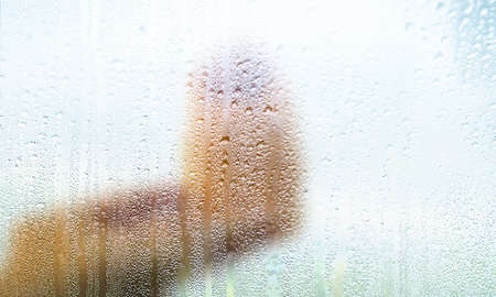 Background with rain drops close up. Rain drops on outdoor window, Closeup view transparent water drops on glass surface, humid water backdrop, blurred background with copy space for your textの写真素材
