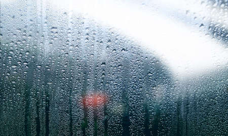 Background with rain drops close up. Rain drops on outdoor window, Closeup view transparent water drops on glass surface, humid water backdrop, blurred background with copy space for your textの写真素材
