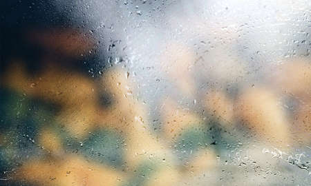 Background with rain drops close up. Rain drops on outdoor window, Closeup view transparent water drops on glass surface, humid water backdrop, blurred background with copy space for your textの写真素材