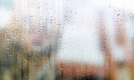 Drops of rain on the window, blurred background. Rainy weather.