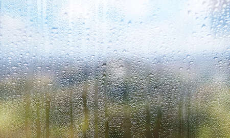 Background with rain drops on glass surface. Rain drops on outdoor window, Closeup view transparent...