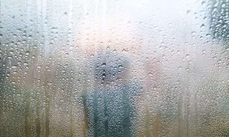 Water drops on the window with blurred background. Rainy weather background.