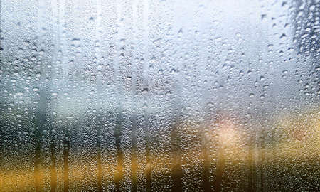 Water drops on window glass close up. Rainy weather background.