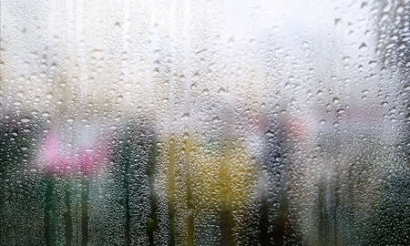 Water drops on window glass with blurred background. Rainy weather background.