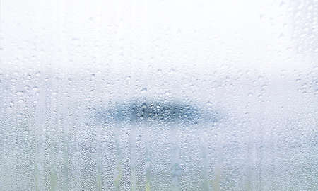 Water drops on window glass, closeup. Rainy weather background