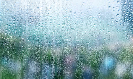 Background with rain drops on glass close up. Rain drops on outdoor window, shallow DOF.