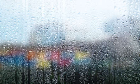 Background with rain drops on glass, closeup view. Rain drops on window, humid water backdrop,...