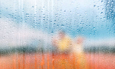Water drops on window glass, closeup. Rainy weather backgroundの写真素材