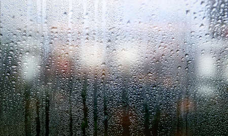 Condensation on the window with a blurry background. Rain drops on the glass. Rainy weather.