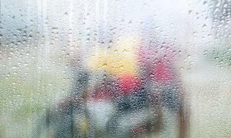 Drops of rain on the window, blurred background. Condensation on the glass, rainy weather.