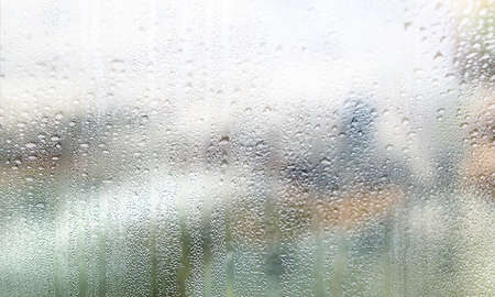 Water drops on window glass, closeup. Rainy weather background