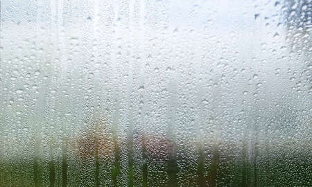Condensation on the window. Drops of water on the glass. Rainy weather.