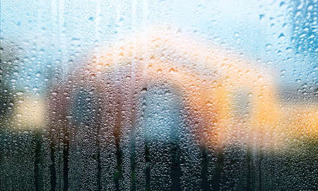 Background with rain drops close up. Rain drops on outdoor window, Closeup view transparent water drops on glass surface, humid water backdrop, blurred background with copy space for your textの写真素材