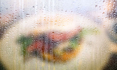 Drops of rain on the window, blurred background with copy space