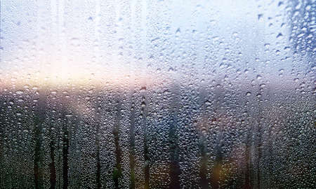 Water drops on the window glass, blurred background. Rainy weather.