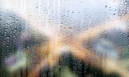 Drops of rain on the window, blurred background. Rainy weather concept.